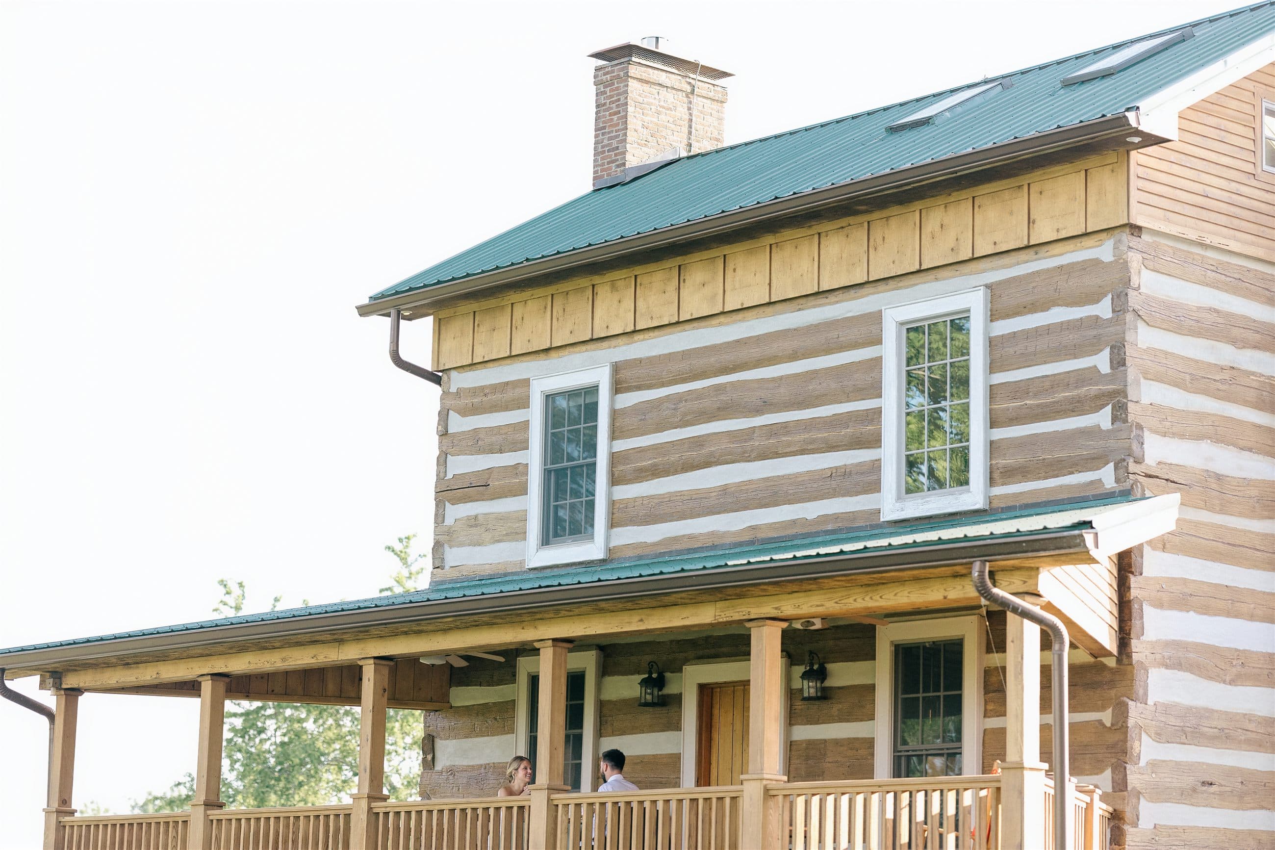 The two-story log cabin and its wide front porch