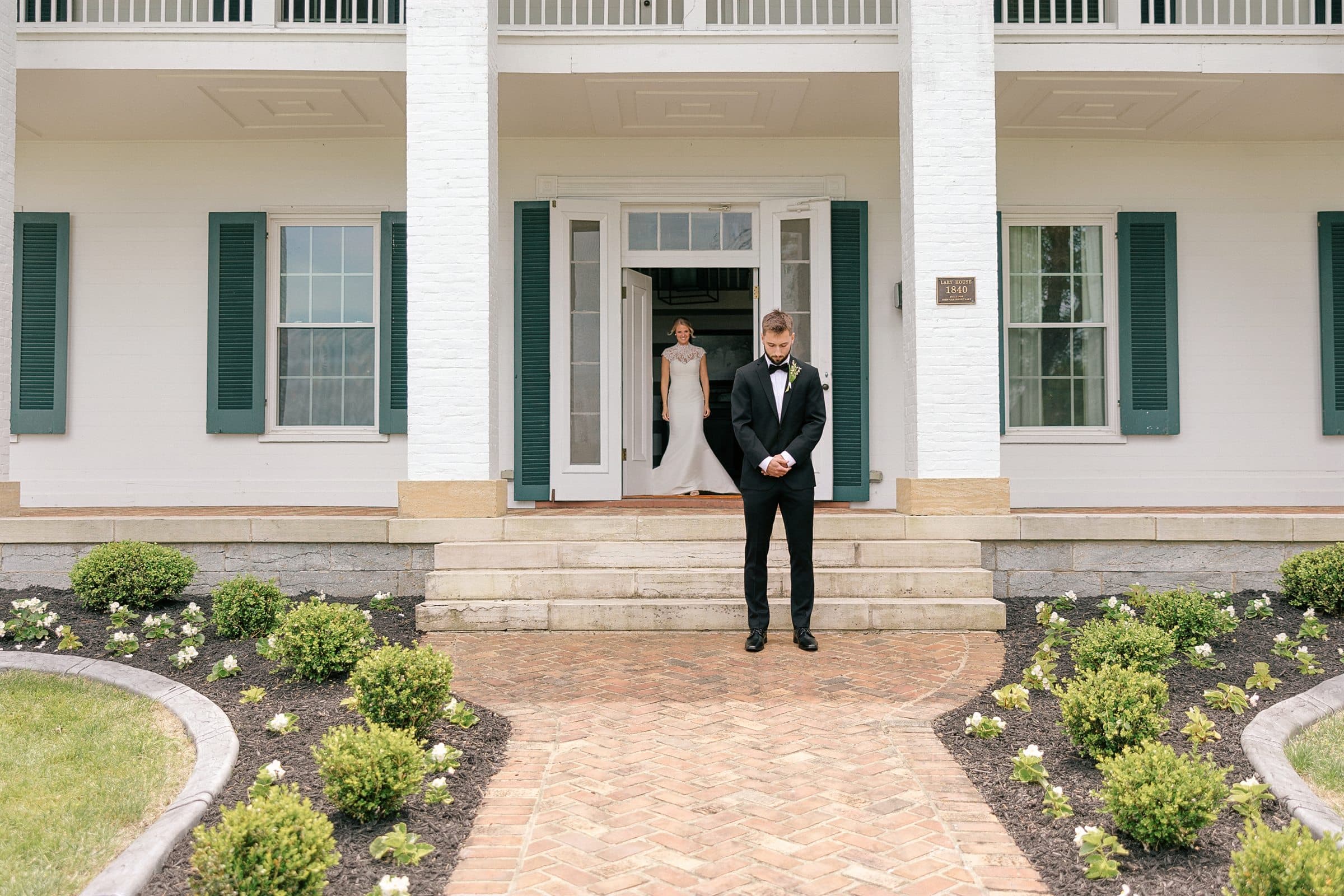 The groom waiting at the manor's front door