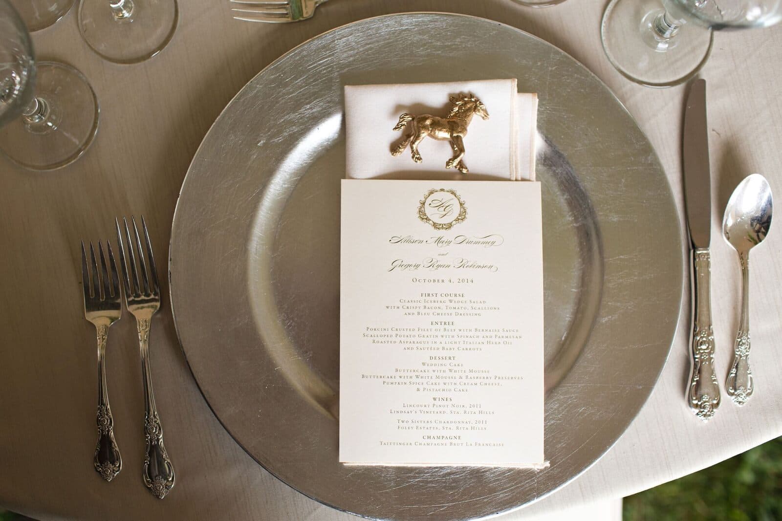 A menu and a small brass horse set at each place